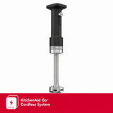 KitchenAid hand blender with a black handle and silver metallic base, shown on a white background with a red KitchenAid Go cordless system banner at the bottom.